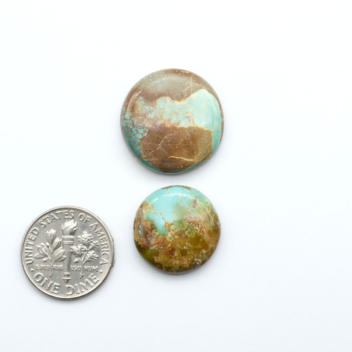 Royston Turquoise cabochons, blue-green color with natural matrix, polished stones on a white background, with a US dime for scale