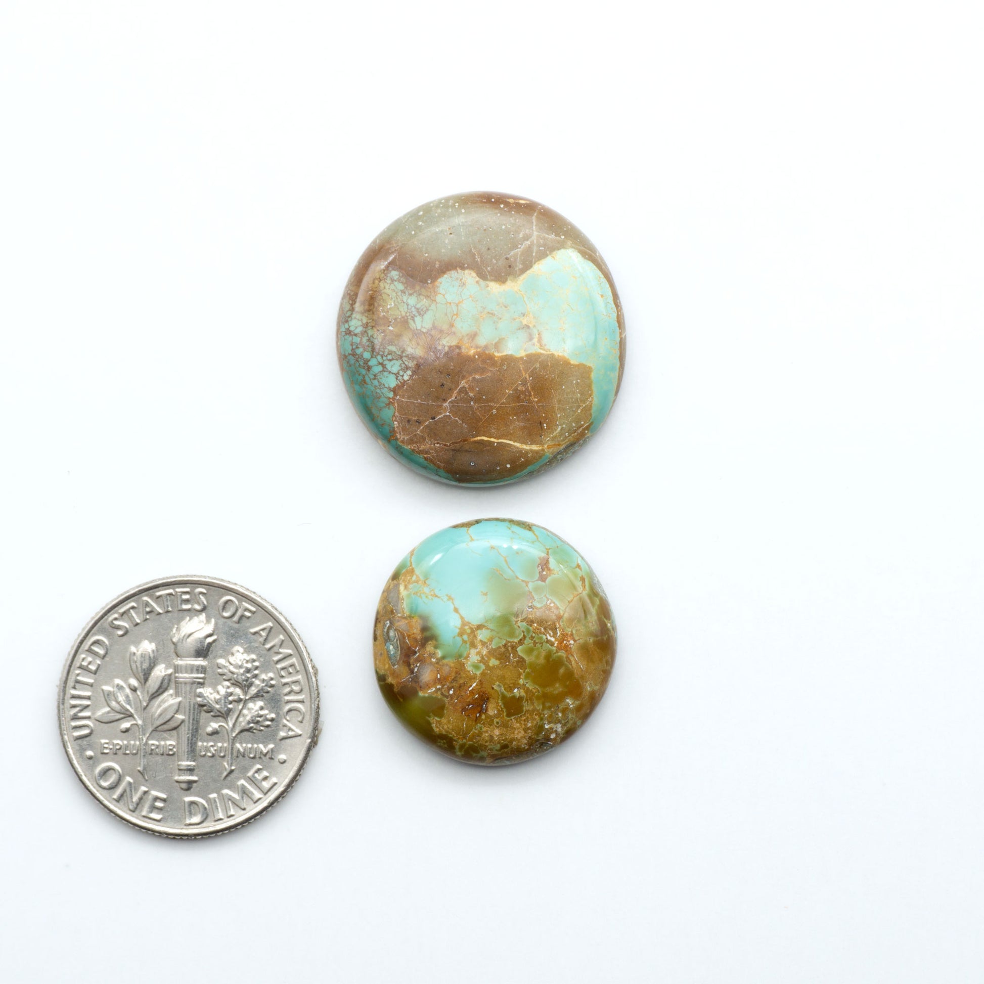 Royston Turquoise cabochons, blue-green color with natural matrix, polished stones on a white background, with a US dime for scale