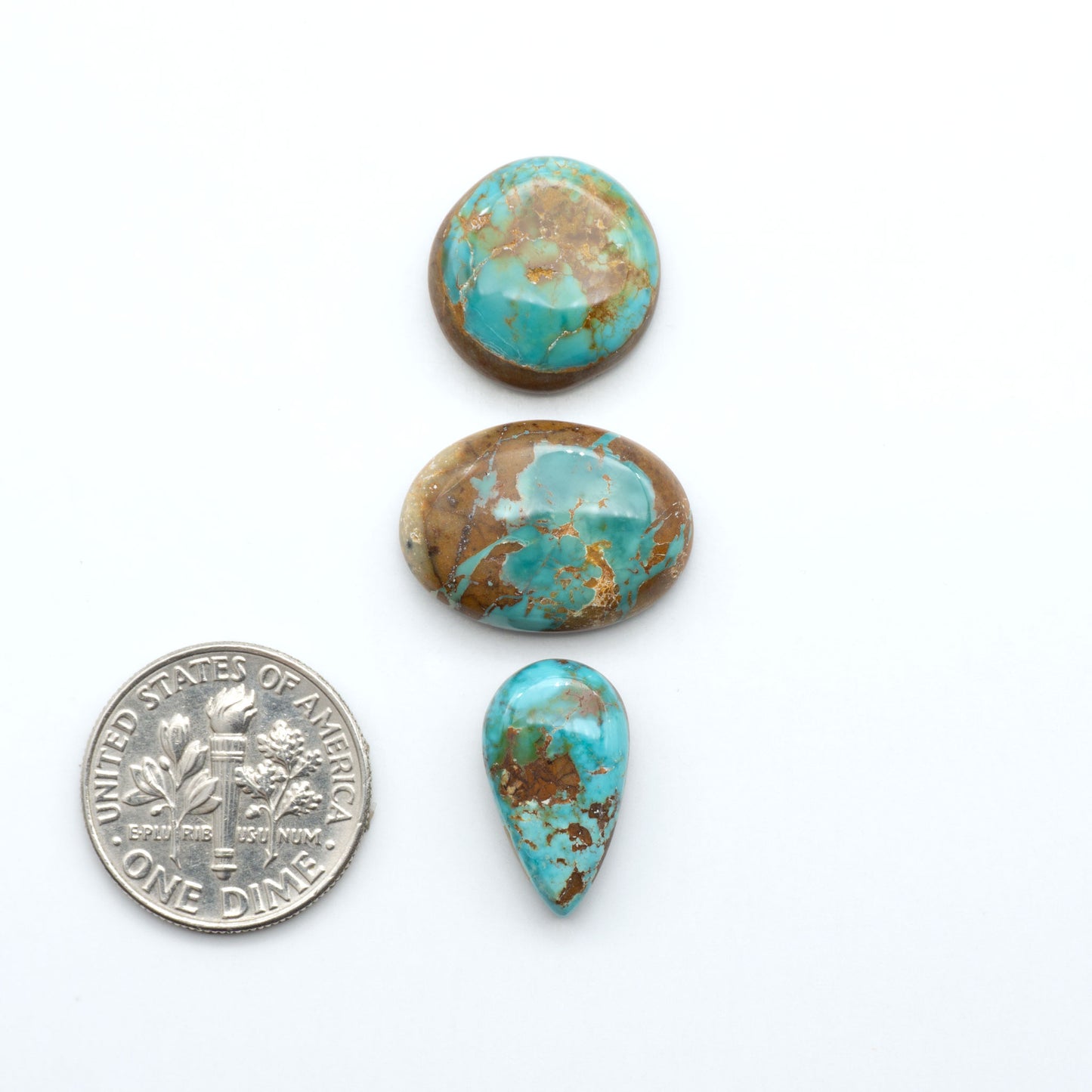Royston Turquoise cabochons, blue-green color with natural matrix, polished stones on a white background, with a US dime for scale