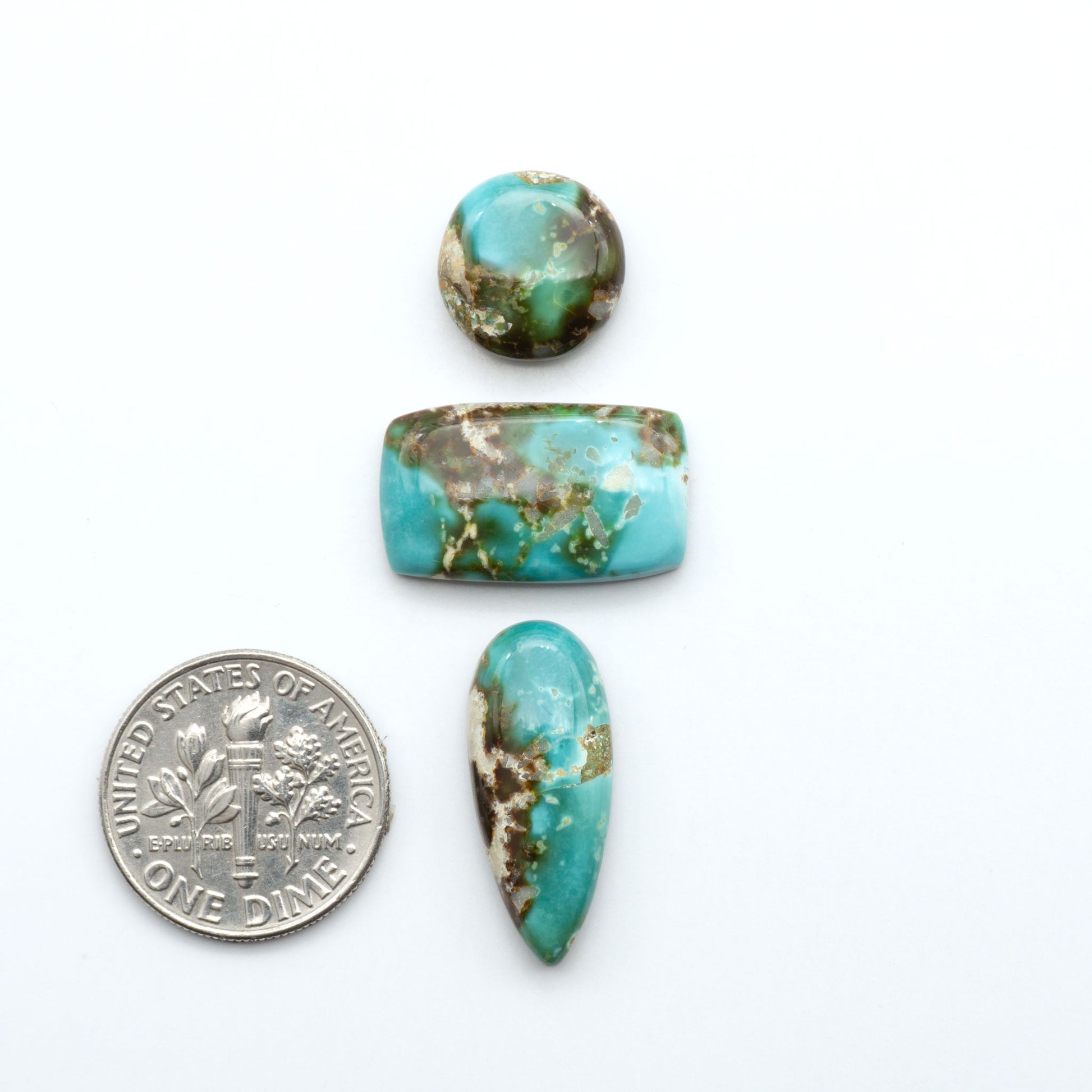 Royston Turquoise cabochons, blue-green color with natural matrix, polished stones on a white background, with a US dime for scale