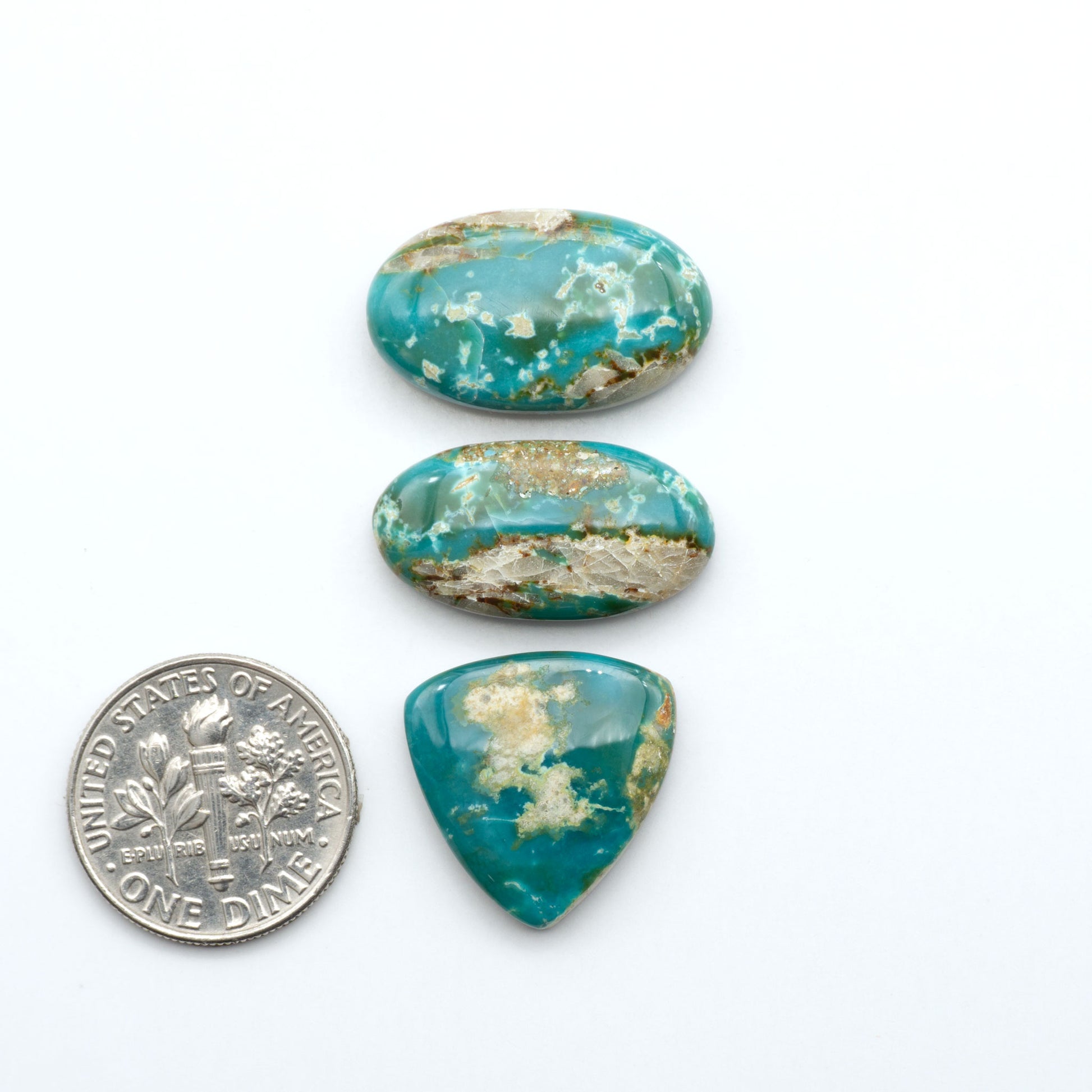 Royston Turquoise cabochons, blue-green color with natural matrix, polished stones on a white background, with a US dime for scale