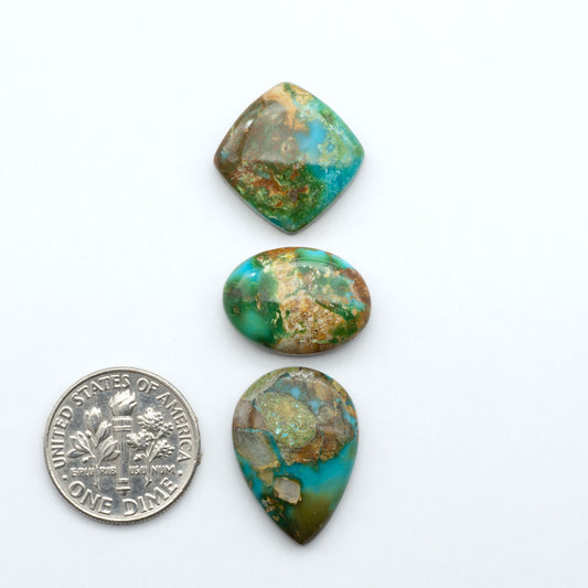 Sonoran Mountain Turquoise cabochons, blue-green color with natural matrix, polished stones on a white background, with a US dime for scale
