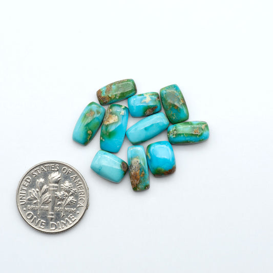 Sonoran Mountain Turquoise cabochons, blue-green color with natural matrix, polished stones on a white background, with a US dime for scale