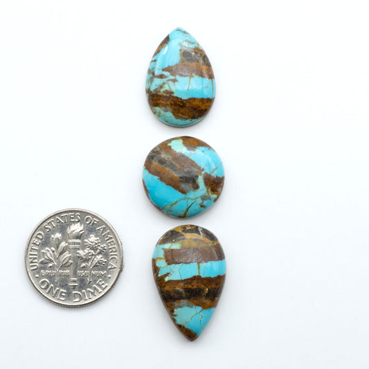 Number 8 Turquoise cabochons, blue and green color with brown matrix, polished stones on a white background, with a US dime for scale