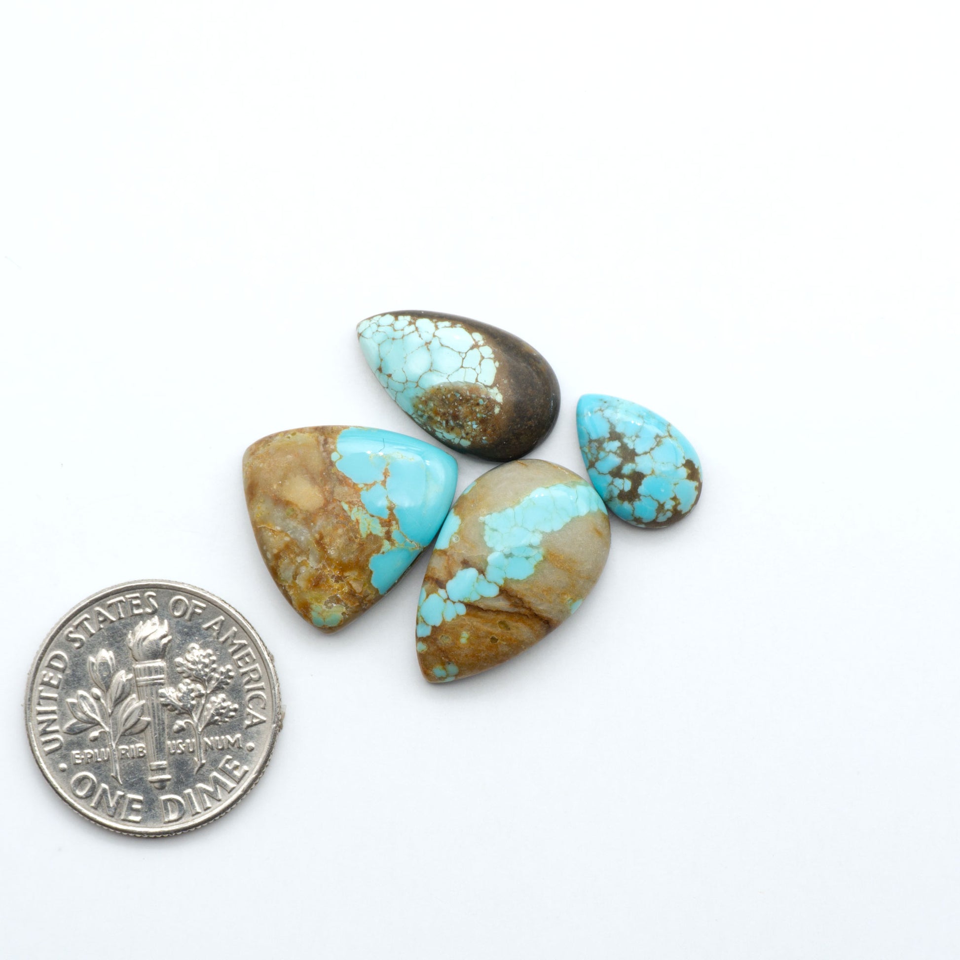 Number 8 Turquoise cabochons, blue and green color with brown matrix, polished stones on a white background, with a US dime for scale