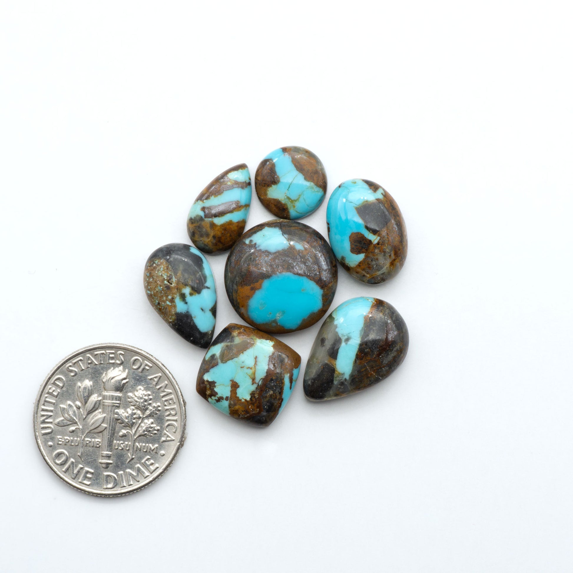 Number 8 Turquoise cabochons, blue and green color with brown matrix, polished stones on a white background, with a US dime for scale