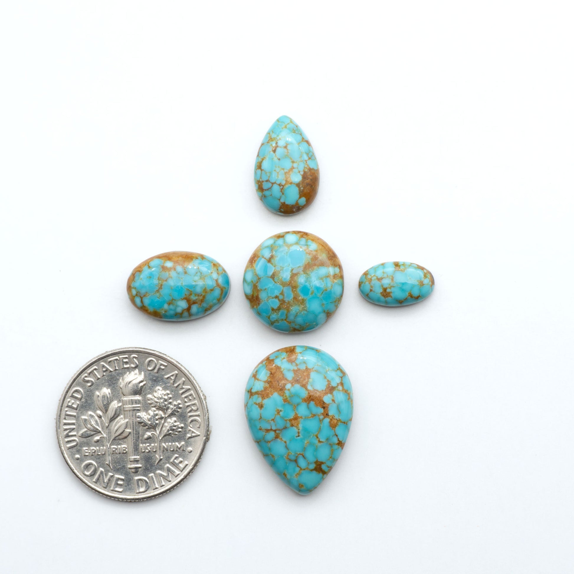 Number 8 Turquoise cabochons, blue and green color with brown matrix, polished stones on a white background, with a US dime for scale
