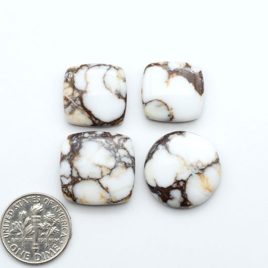 Wild Horse Magnesite cabochons, white gemstones with brown matrix on a white background, with a US dime for scale