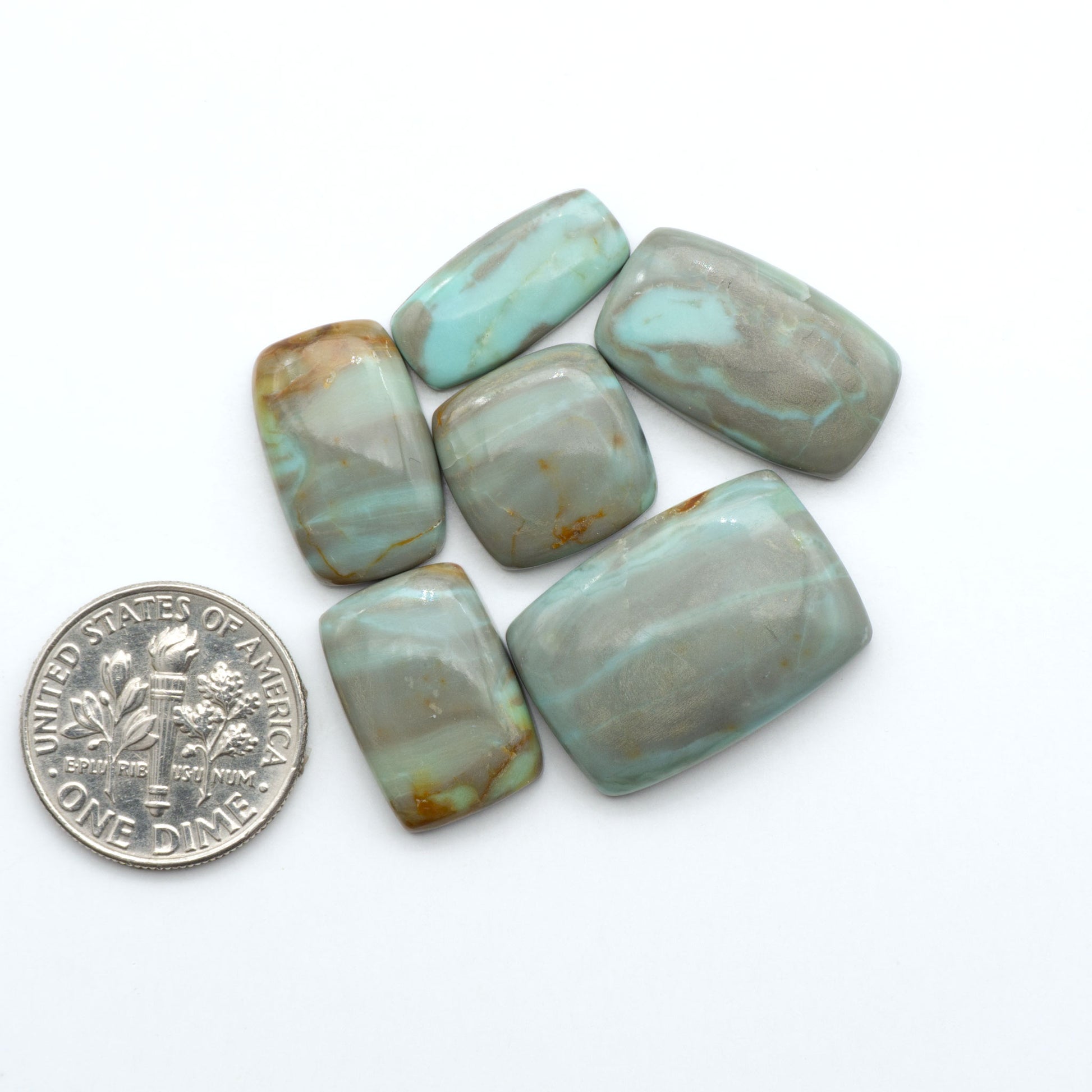 Number 8 Turquoise cabochons, blue and green color with brown matrix, polished stones on a white background, with a US dime for scale