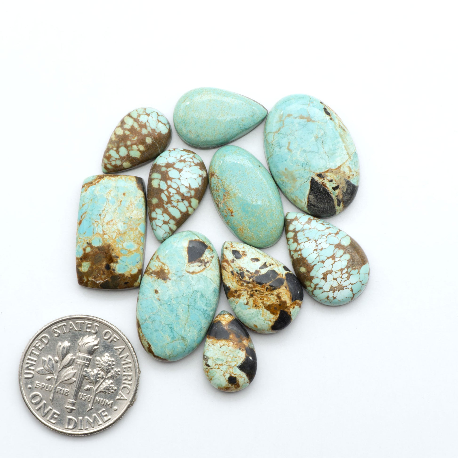 Number 8 Turquoise cabochons, blue and green color with brown matrix, polished stones on a white background, with a US dime for scale