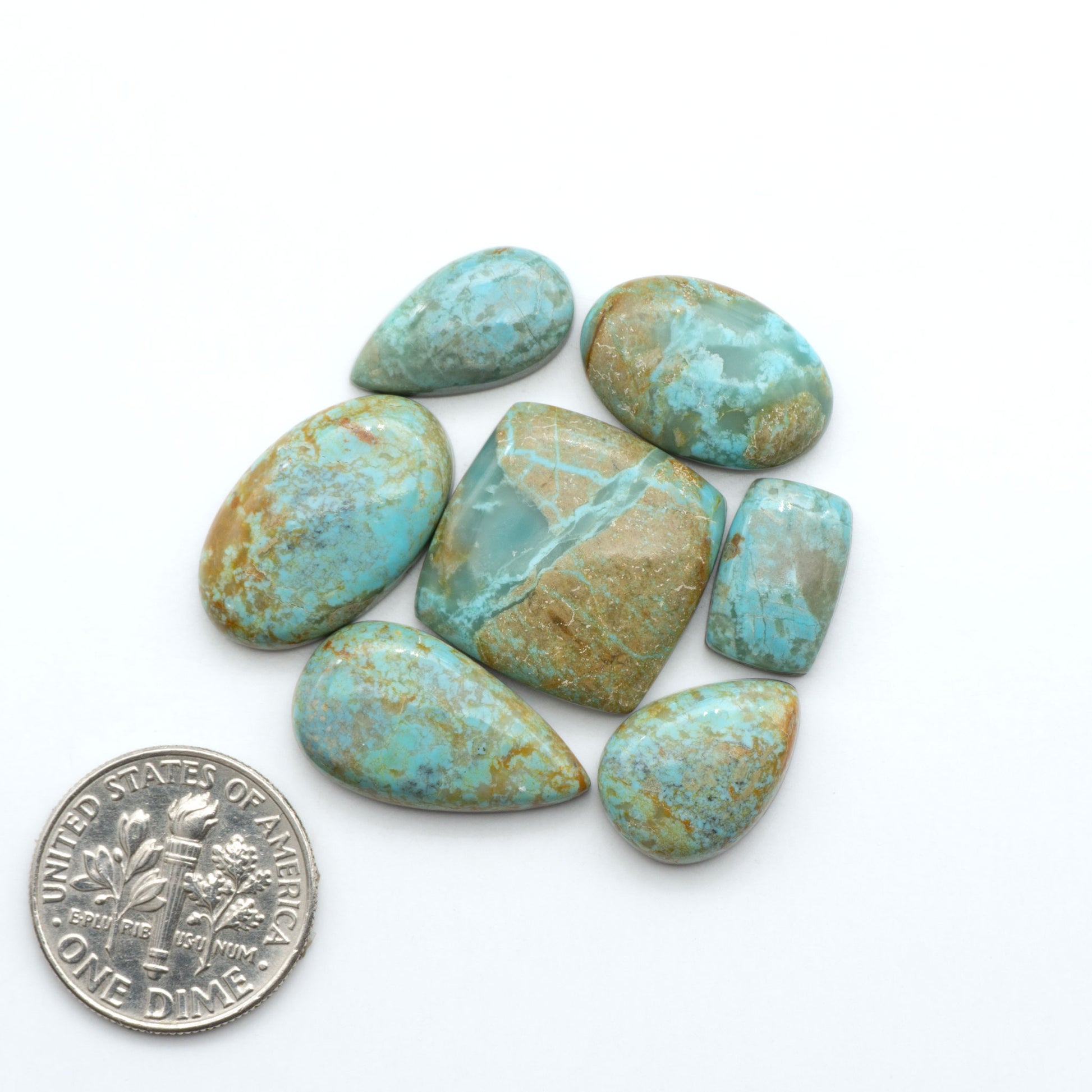 Number 8 Turquoise cabochons, blue and green color with brown matrix, polished stones on a white background, with a US dime for scale