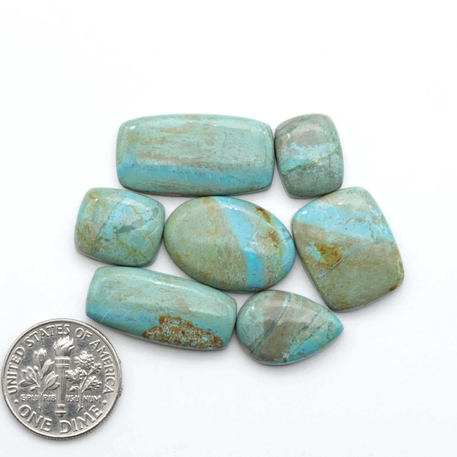 Number 8 Turquoise cabochons, blue and green color with brown matrix, polished stones on a white background, with a US dime for scale