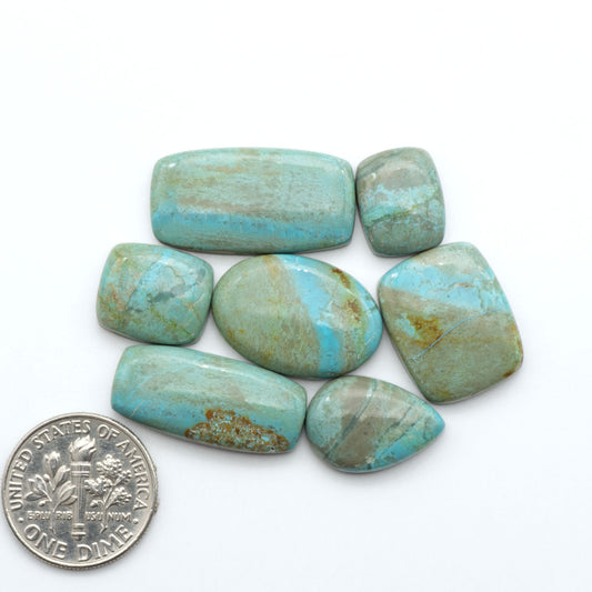 Number 8 Turquoise cabochons, blue and green color with brown matrix, polished stones on a white background, with a US dime for scale