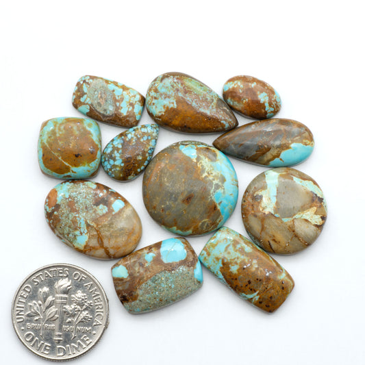 Number 8 Turquoise cabochons, blue and green color with brown matrix, polished stones on a white background, with a US dime for scale