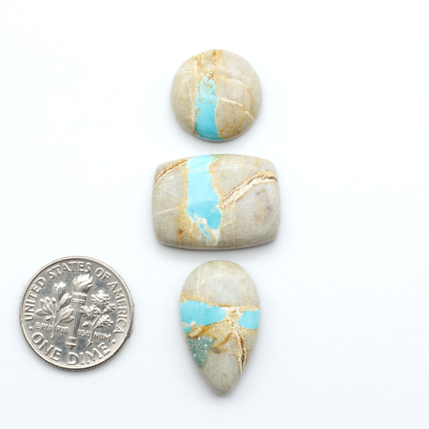 Royston Turquoise cabochons, blue-green color with natural matrix, polished stones on a white background, with a US dime for scale