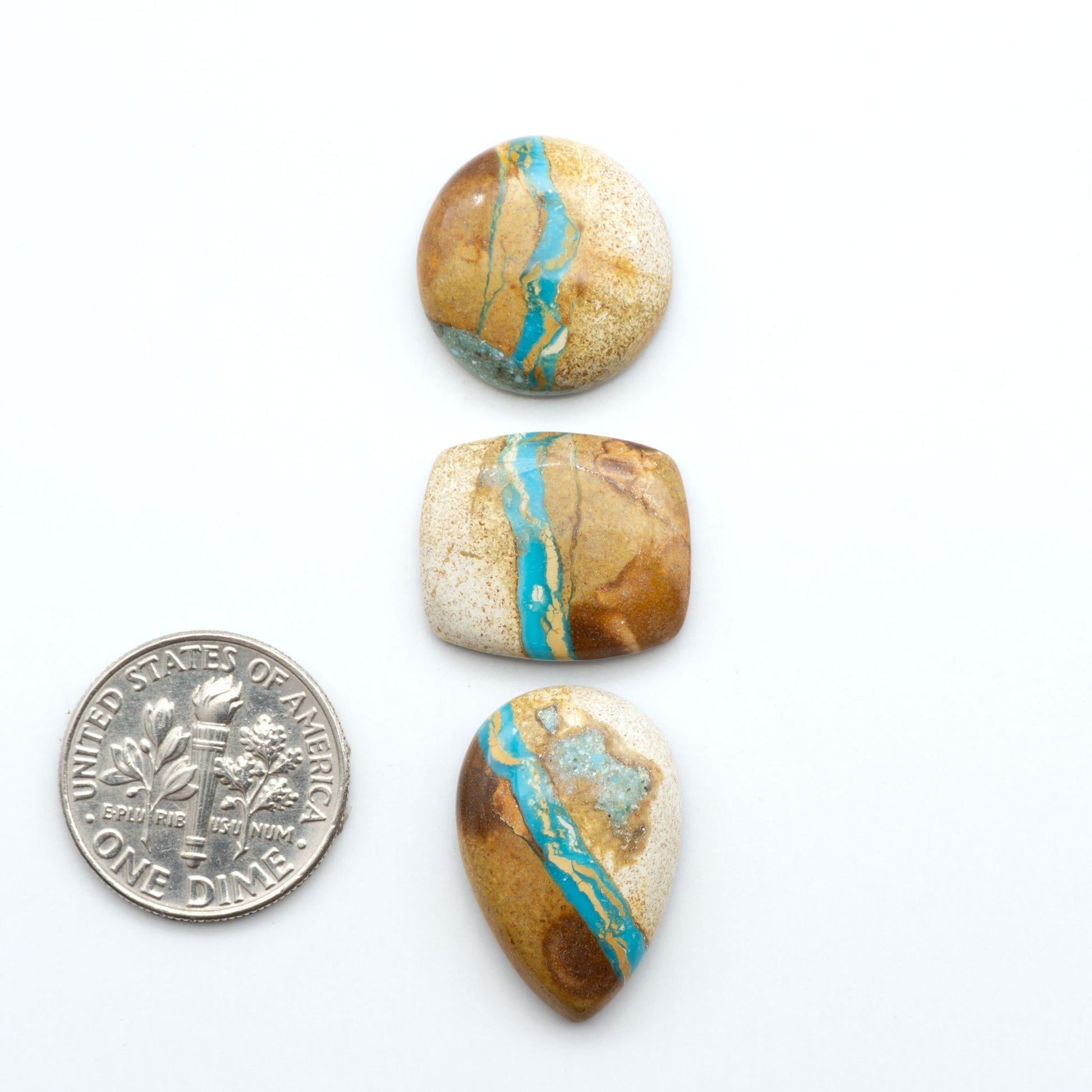 Royston Turquoise cabochons, blue-green color with natural matrix, polished stones on a white background, with a US dime for scale