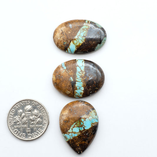 Royston Turquoise cabochons, blue-green color with natural matrix, polished stones on a white background, with a US dime for scale