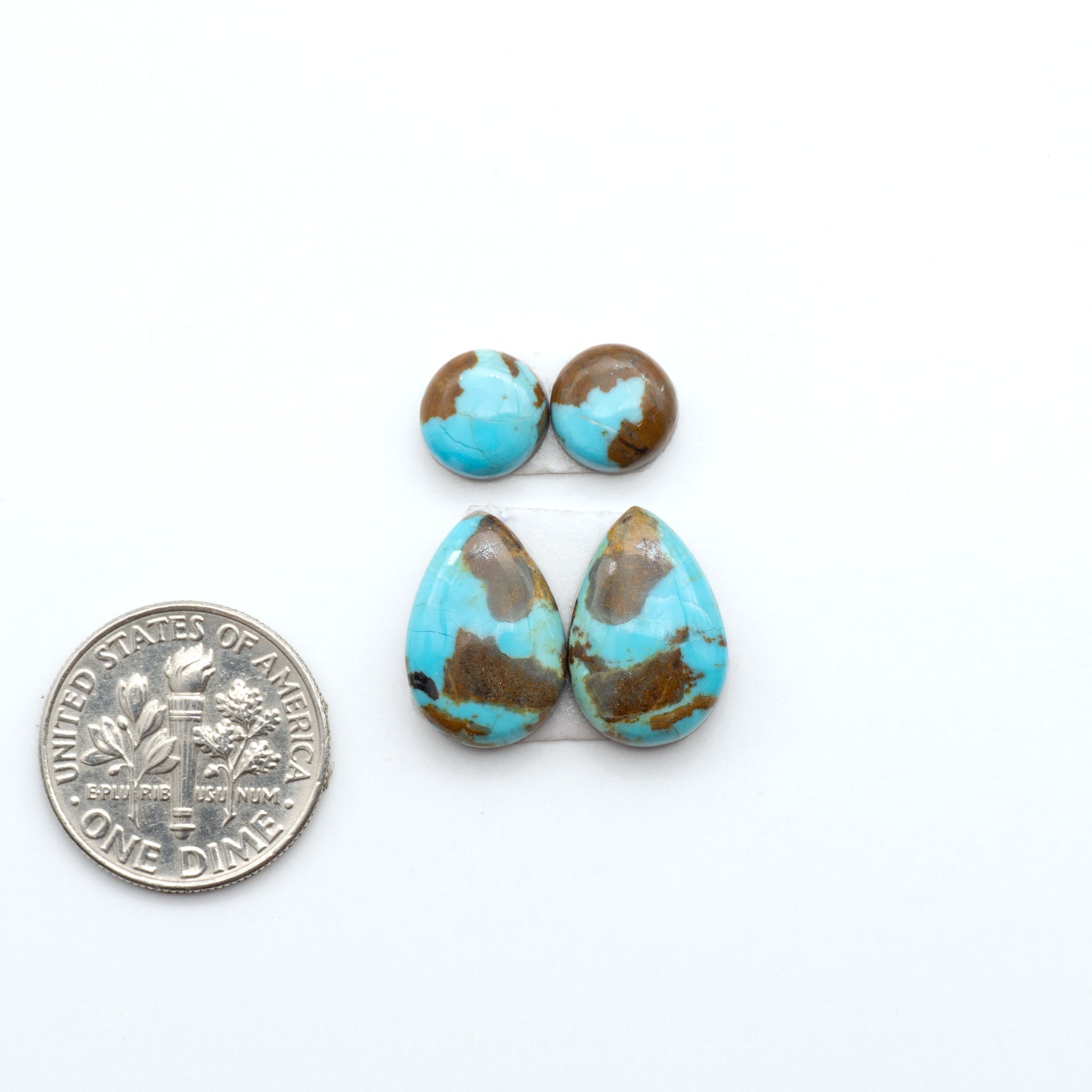 Number 8 Turquoise cabochons, blue and green color with brown matrix, polished stones on a white background, with a US dime for scale