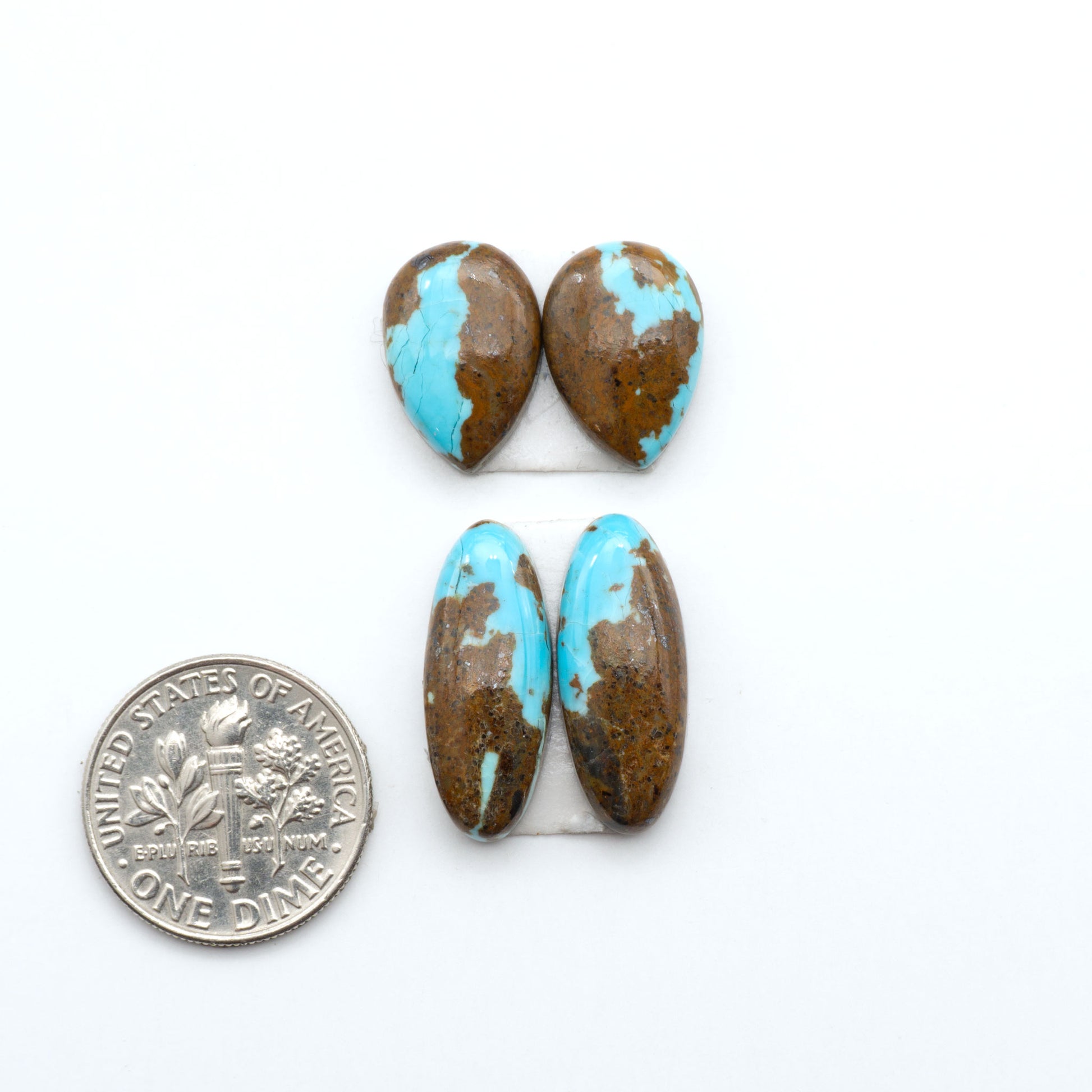Number 8 Turquoise cabochons, blue and green color with brown matrix, polished stones on a white background, with a US dime for scale