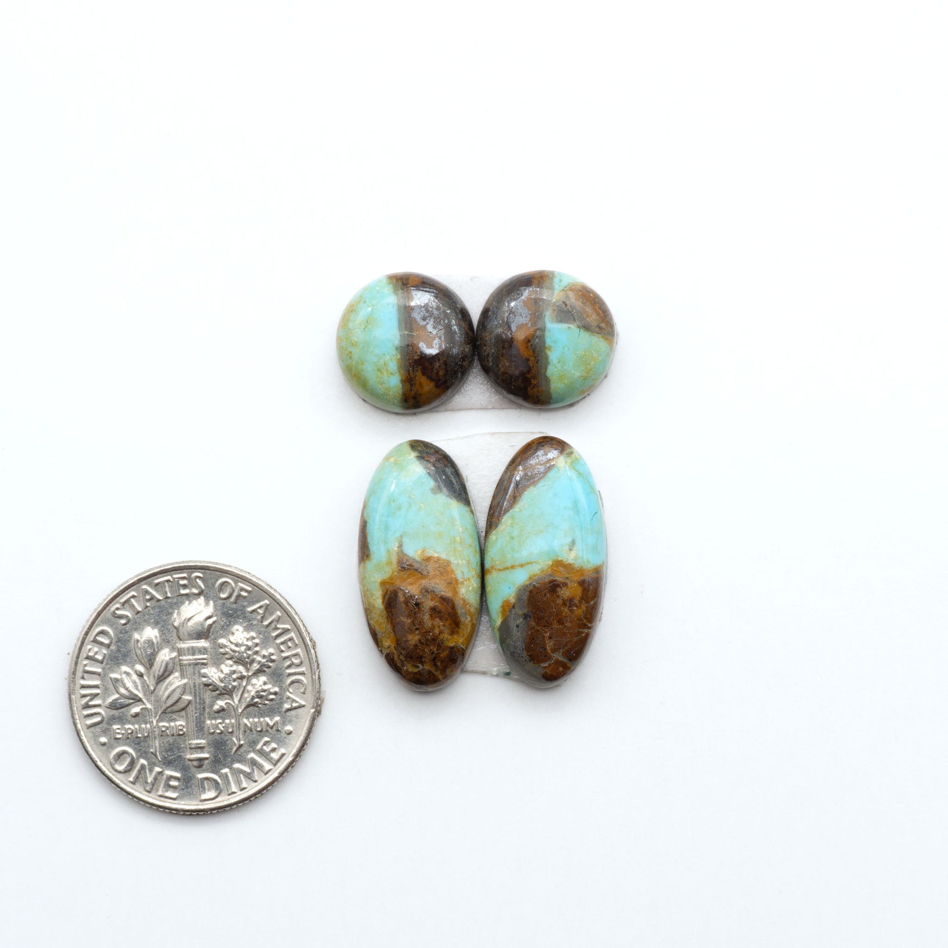 Number 8 Turquoise cabochons, blue and green color with brown matrix, polished stones on a white background, with a US dime for scale