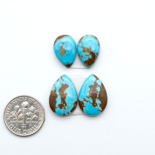 Number 8 Turquoise cabochons, blue and green color with brown matrix, polished stones on a white background, with a US dime for scale