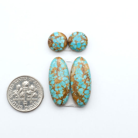 Number 8 Turquoise cabochons, blue and green color with brown matrix, polished stones on a white background, with a US dime for scale