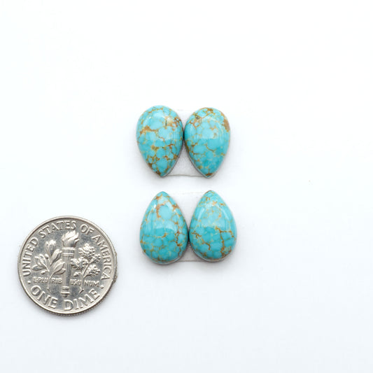 Number 8 Turquoise cabochons, blue and green color with brown matrix, polished stones on a white background, with a US dime for scale