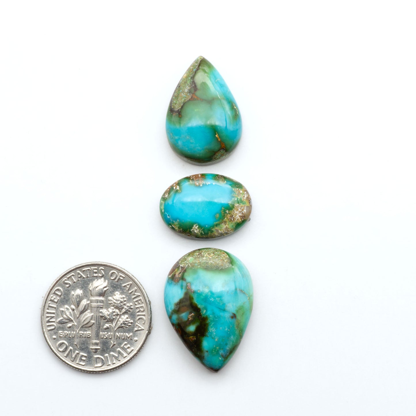 Sonoran Mountain Turquoise cabochons, blue-green color with natural matrix, polished stones on a white background, with a US dime for scale