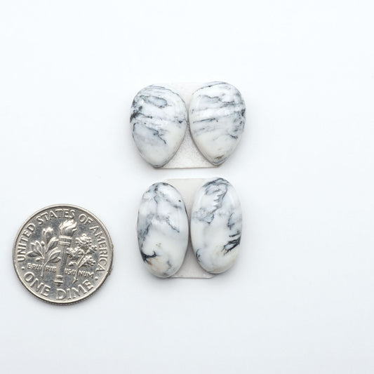 White Buffalo stone cabochons, white stone with black matrix, polished stones on a white background, with a US dime for scale