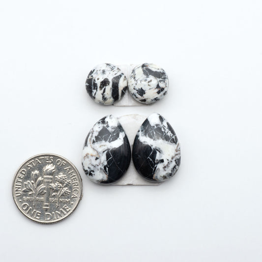 White Buffalo stone cabochons, white stone with black matrix, polished stones on a white background, with a US dime for scale