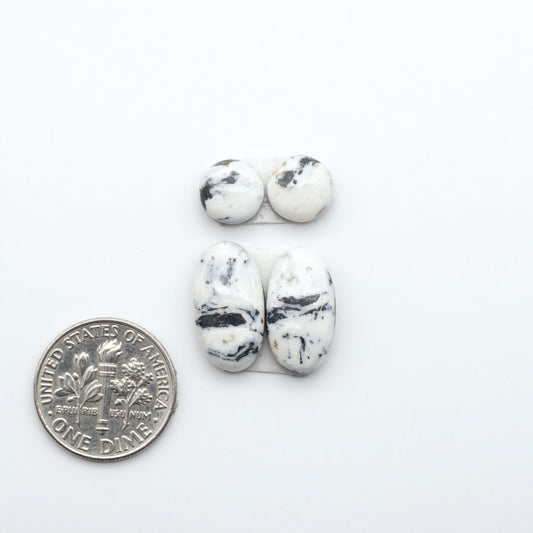 White Buffalo stone cabochons, white stone with black matrix, polished stones on a white background, with a US dime for scale