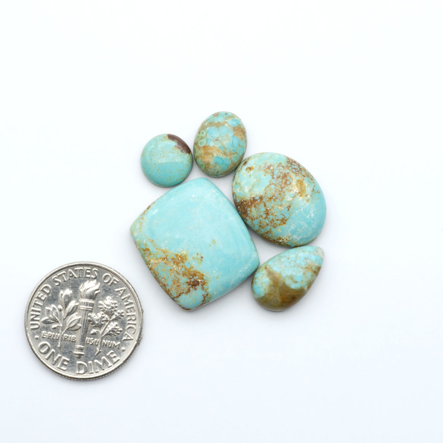 Number 8 Turquoise cabochons, blue and green color with brown matrix, polished stones on a white background, with a US dime for scale
