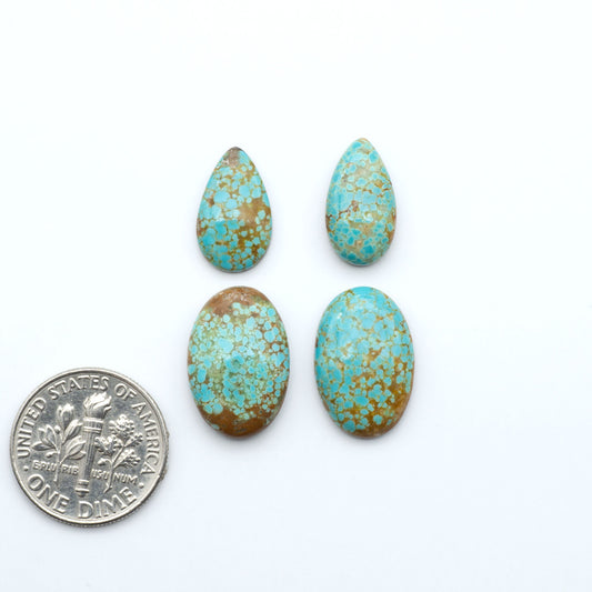 Number 8 Turquoise cabochons, blue and green color with brown matrix, polished stones on a white background, with a US dime for scale