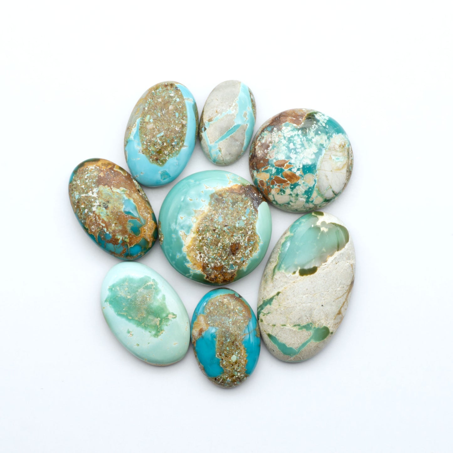 Royston Turquoise cabochons, blue-green color with natural matrix, polished stones on a white background, with a US dime for scale