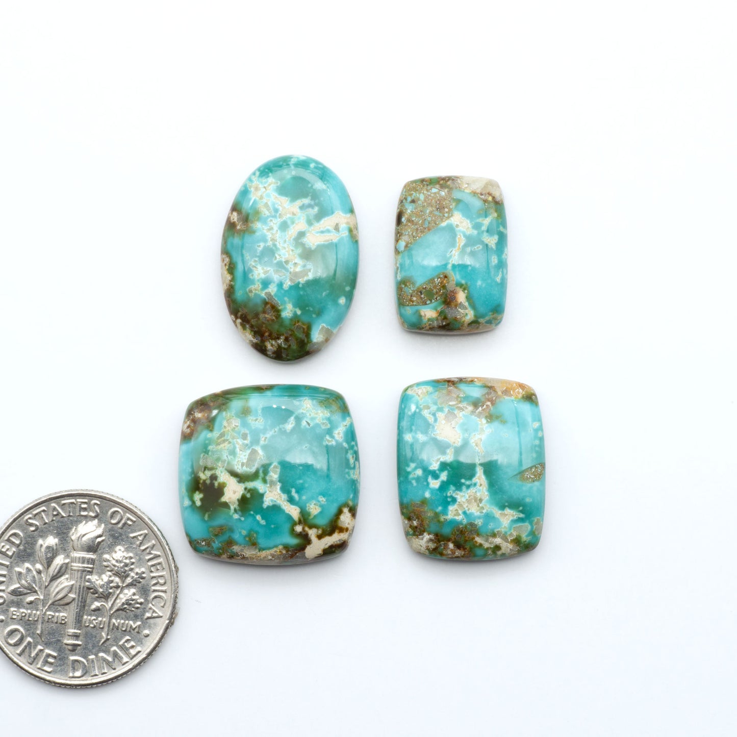 Royston Turquoise cabochons, blue-green color with natural matrix, polished stones on a white background, with a US dime for scale