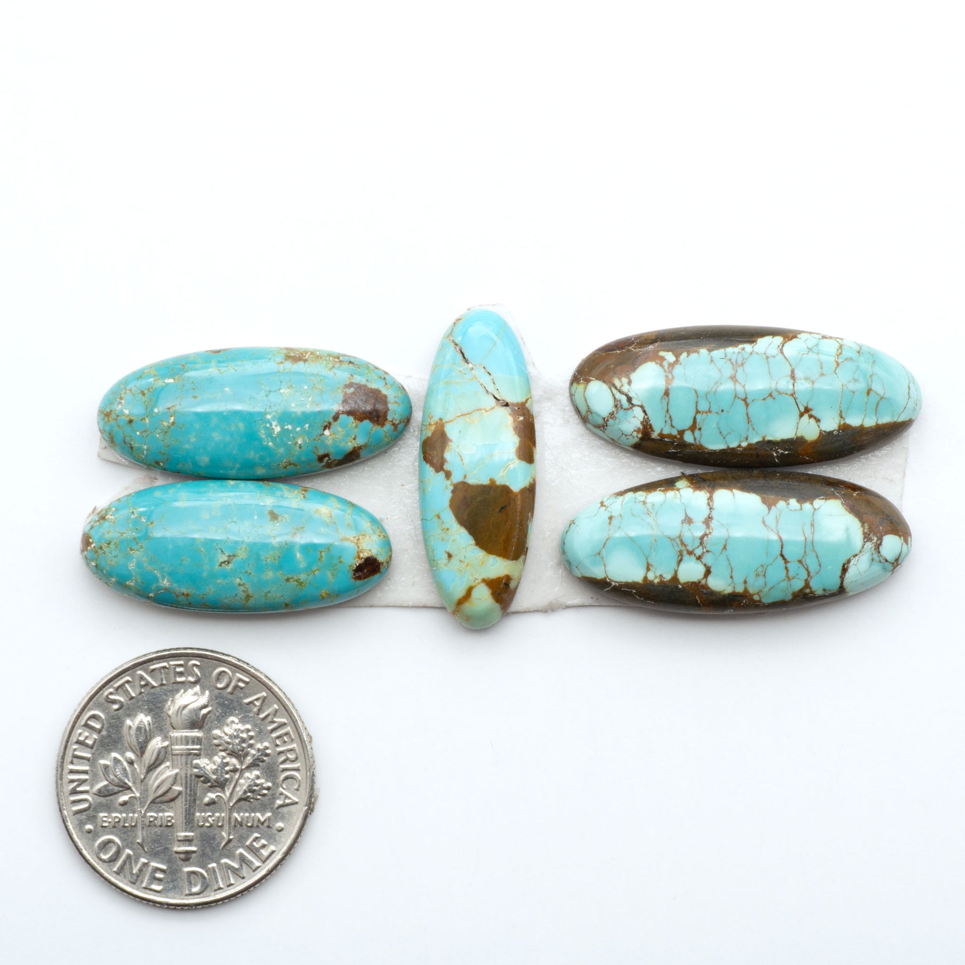 Number 8 Turquoise cabochons, blue and green color with brown matrix, polished stones on a white background, with a US dime for scale