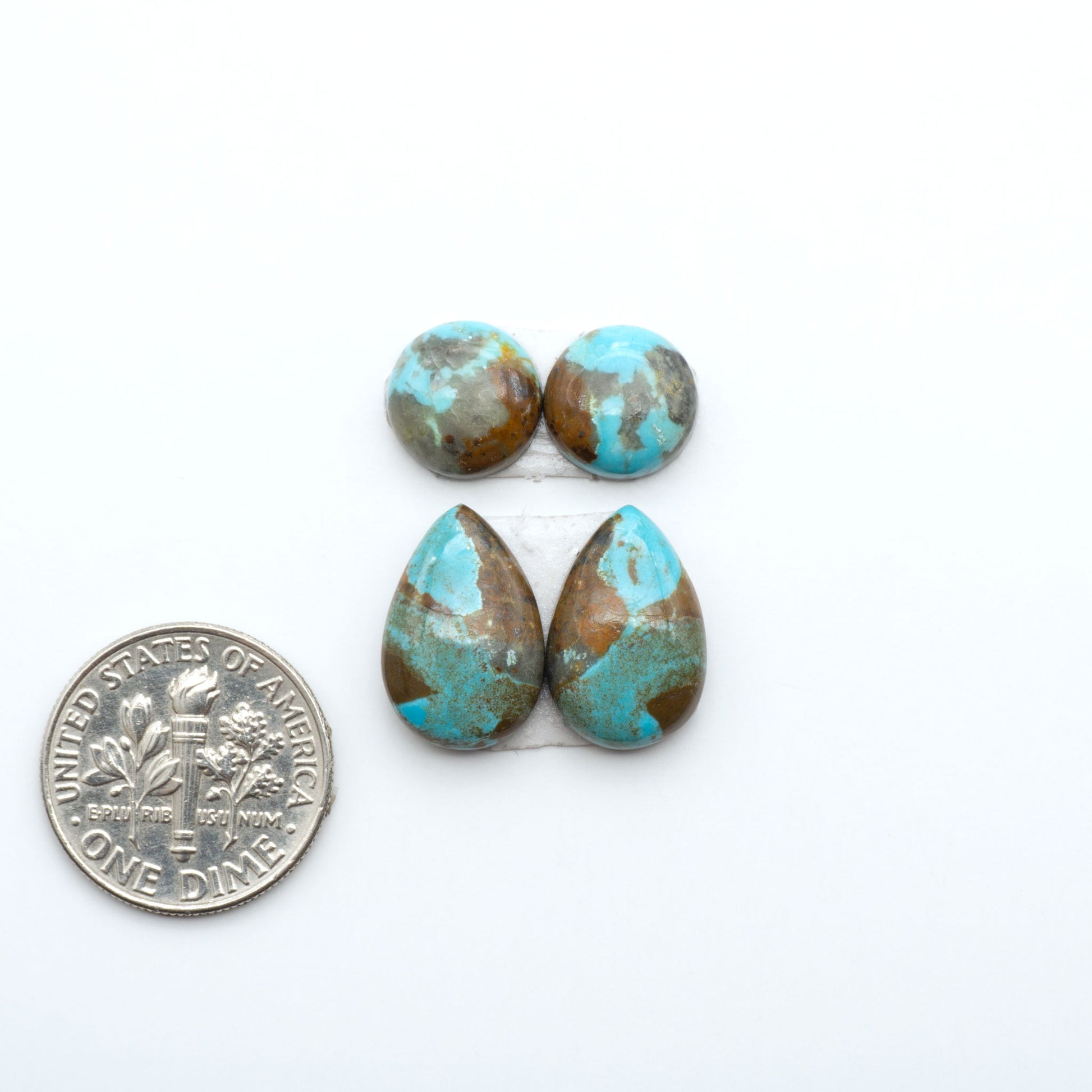 Number 8 Turquoise cabochons, blue and green color with brown matrix, polished stones on a white background, with a US dime for scale