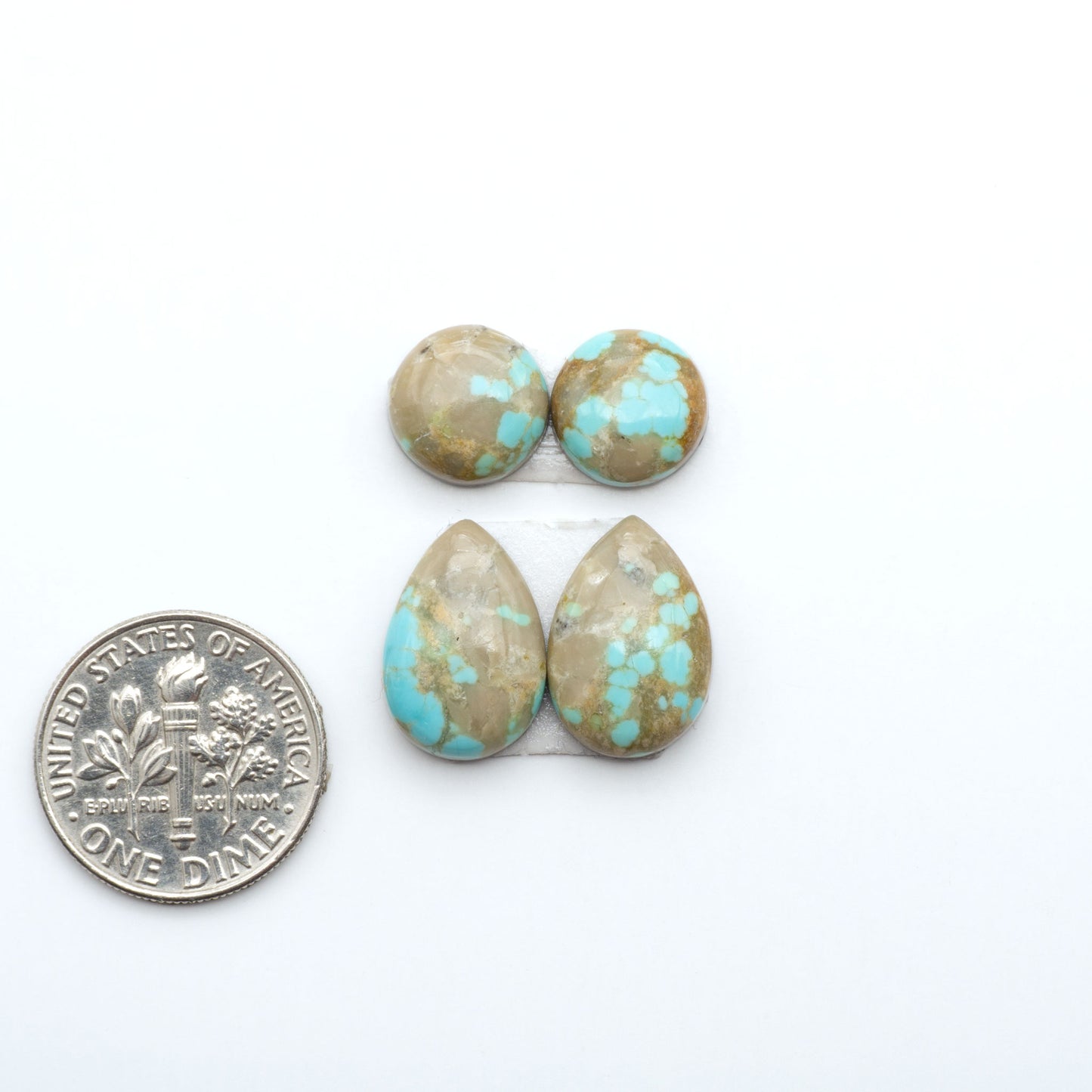 Number 8 Turquoise cabochons, blue and green color with brown matrix, polished stones on a white background, with a US dime for scale
