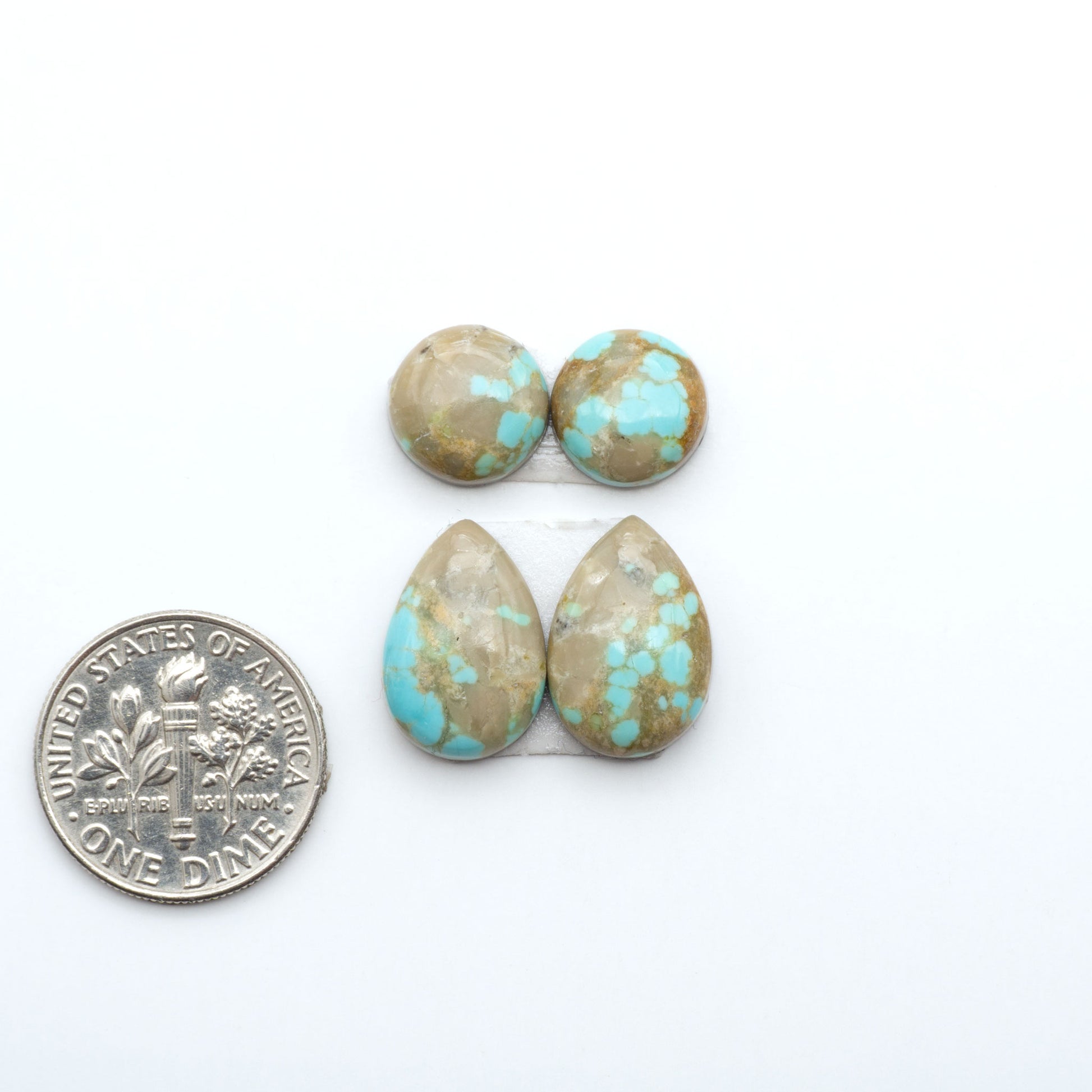 Number 8 Turquoise cabochons, blue and green color with brown matrix, polished stones on a white background, with a US dime for scale