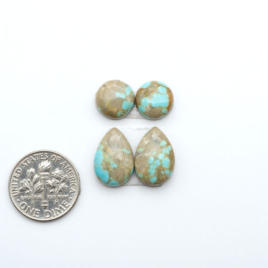 Number 8 Turquoise cabochons, blue and green color with brown matrix, polished stones on a white background, with a US dime for scale