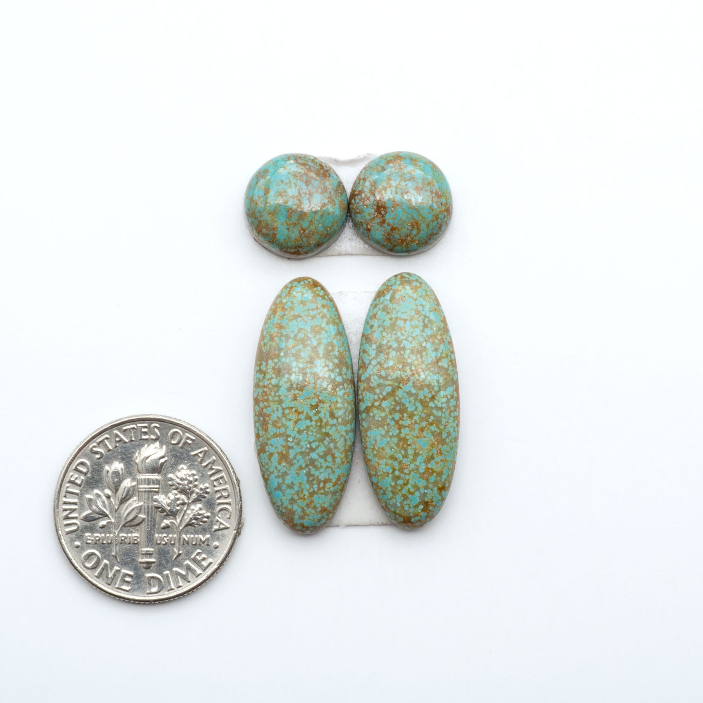 Number 8 Turquoise cabochons, blue and green color with brown matrix, polished stones on a white background, with a US dime for scale