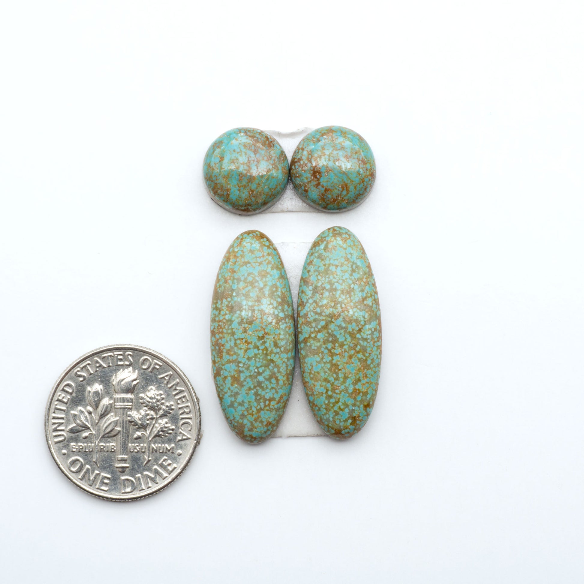 Number 8 Turquoise cabochons, blue and green color with brown matrix, polished stones on a white background, with a US dime for scale