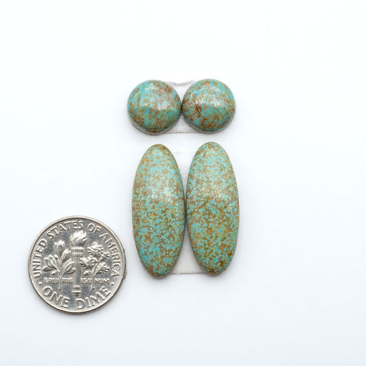 Number 8 Turquoise cabochons, blue and green color with brown matrix, polished stones on a white background, with a US dime for scale