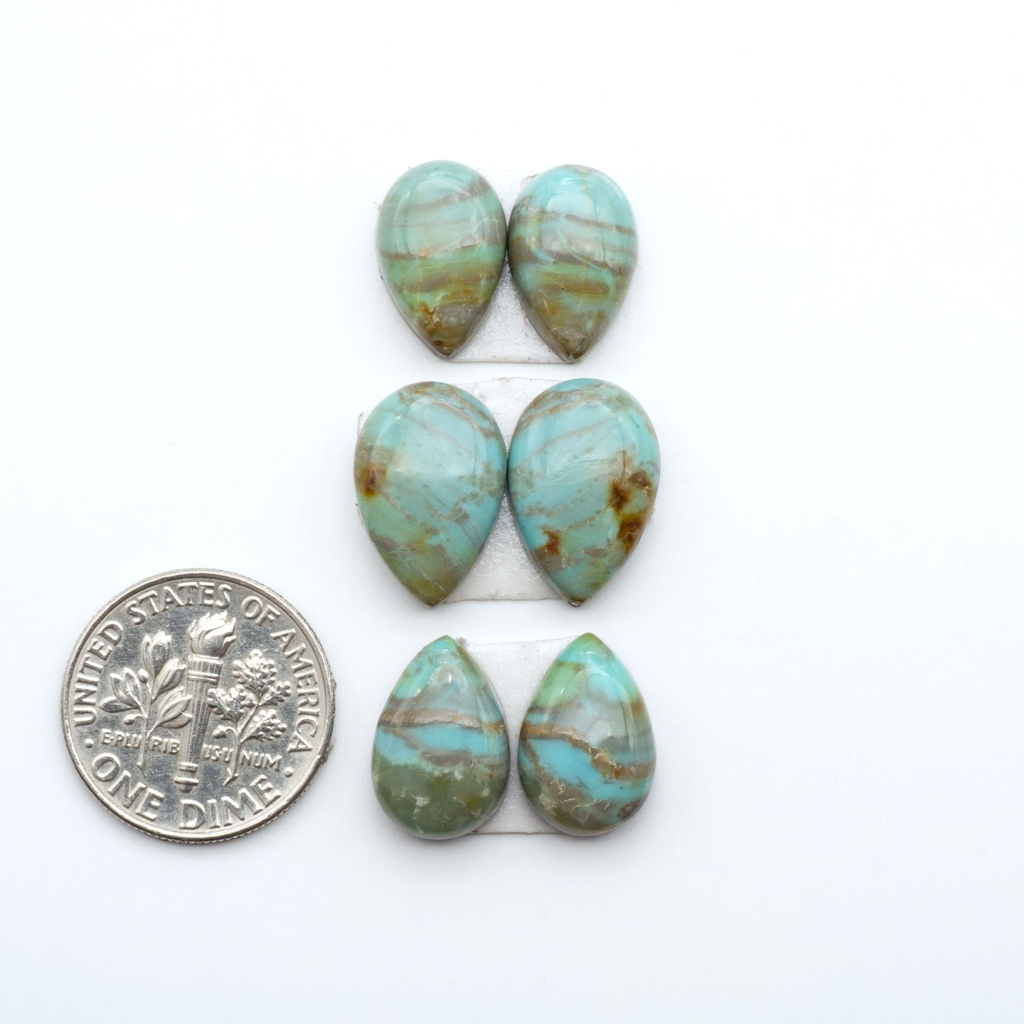 Number 8 Turquoise cabochons, blue and green color with brown matrix, polished stones on a white background, with a US dime for scale