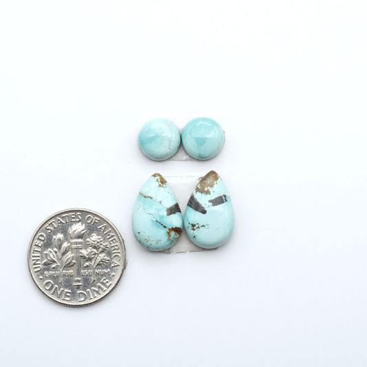 Number 8 Turquoise cabochons, blue and green color with brown matrix, polished stones on a white background, with a US dime for scale