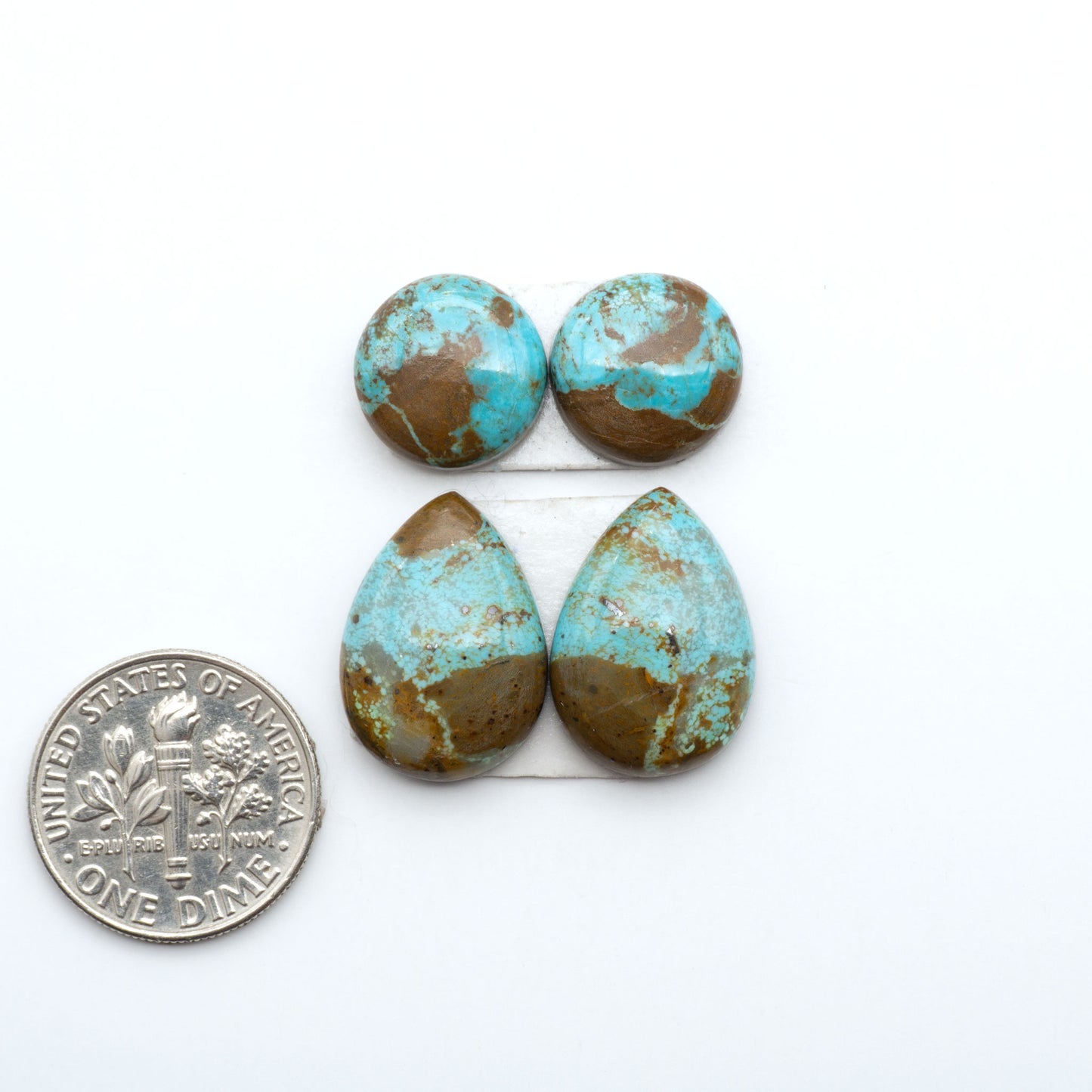 Number 8 Turquoise cabochons, blue and green color with brown matrix, polished stones on a white background, with a US dime for scale