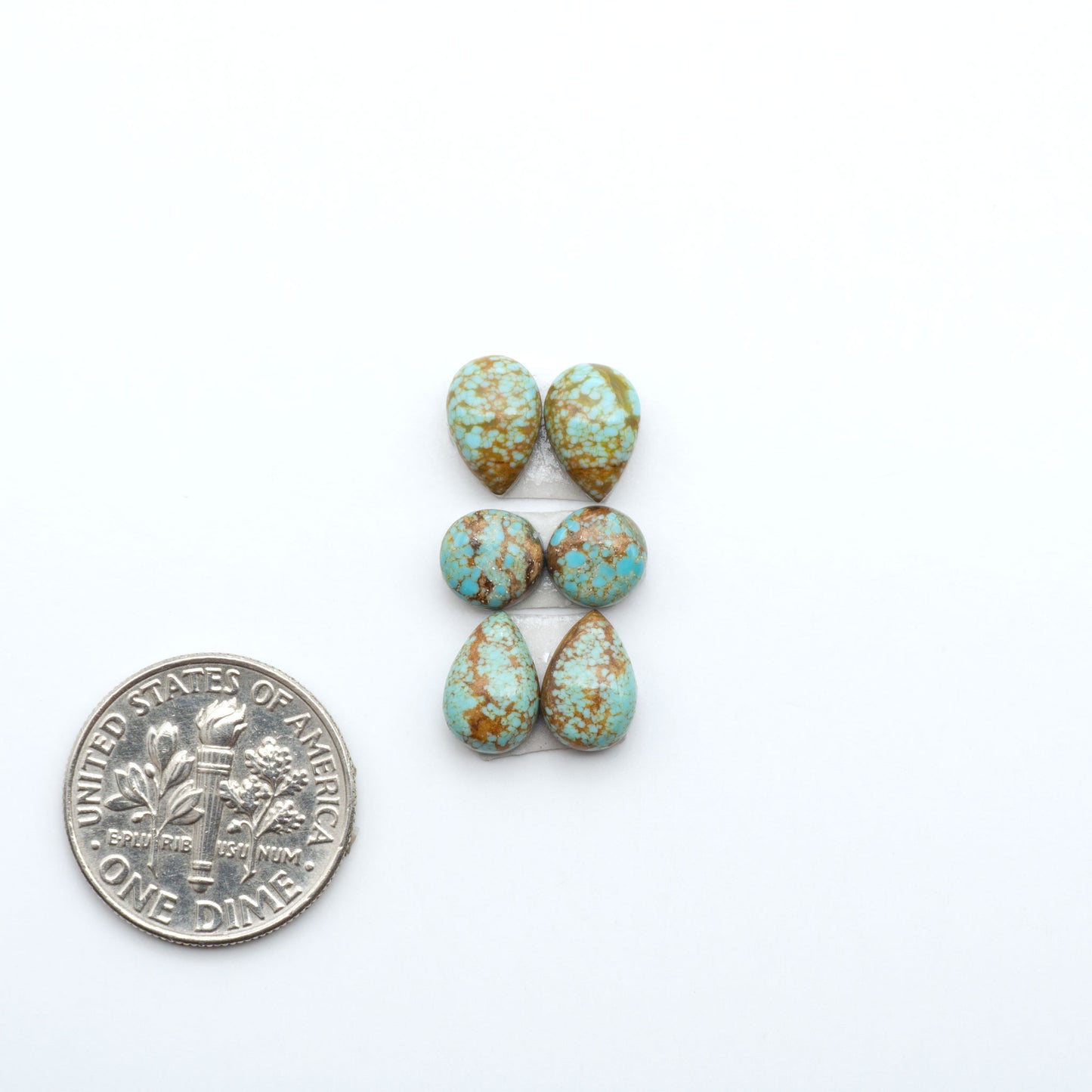 Number 8 Turquoise cabochons, blue and green color with brown matrix, polished stones on a white background, with a US dime for scale