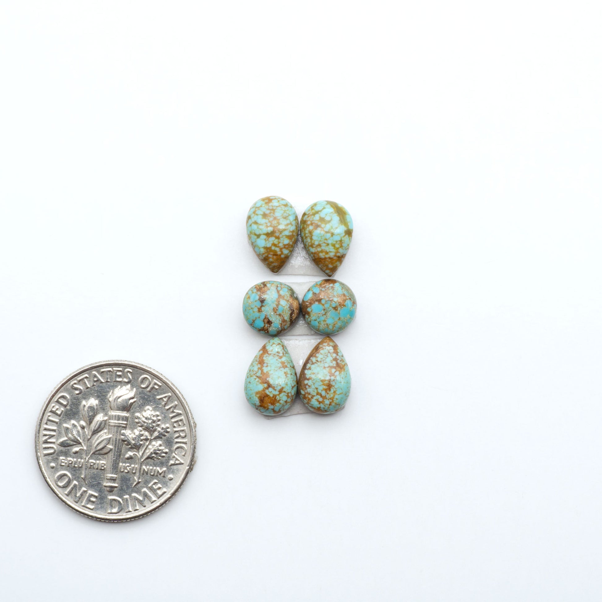 Number 8 Turquoise cabochons, blue and green color with brown matrix, polished stones on a white background, with a US dime for scale