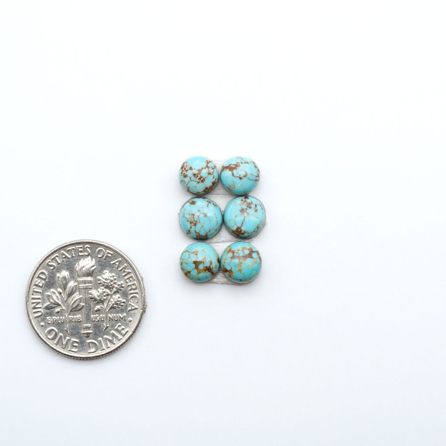 Number 8 Turquoise cabochons, blue and green color with brown matrix, polished stones on a white background, with a US dime for scale