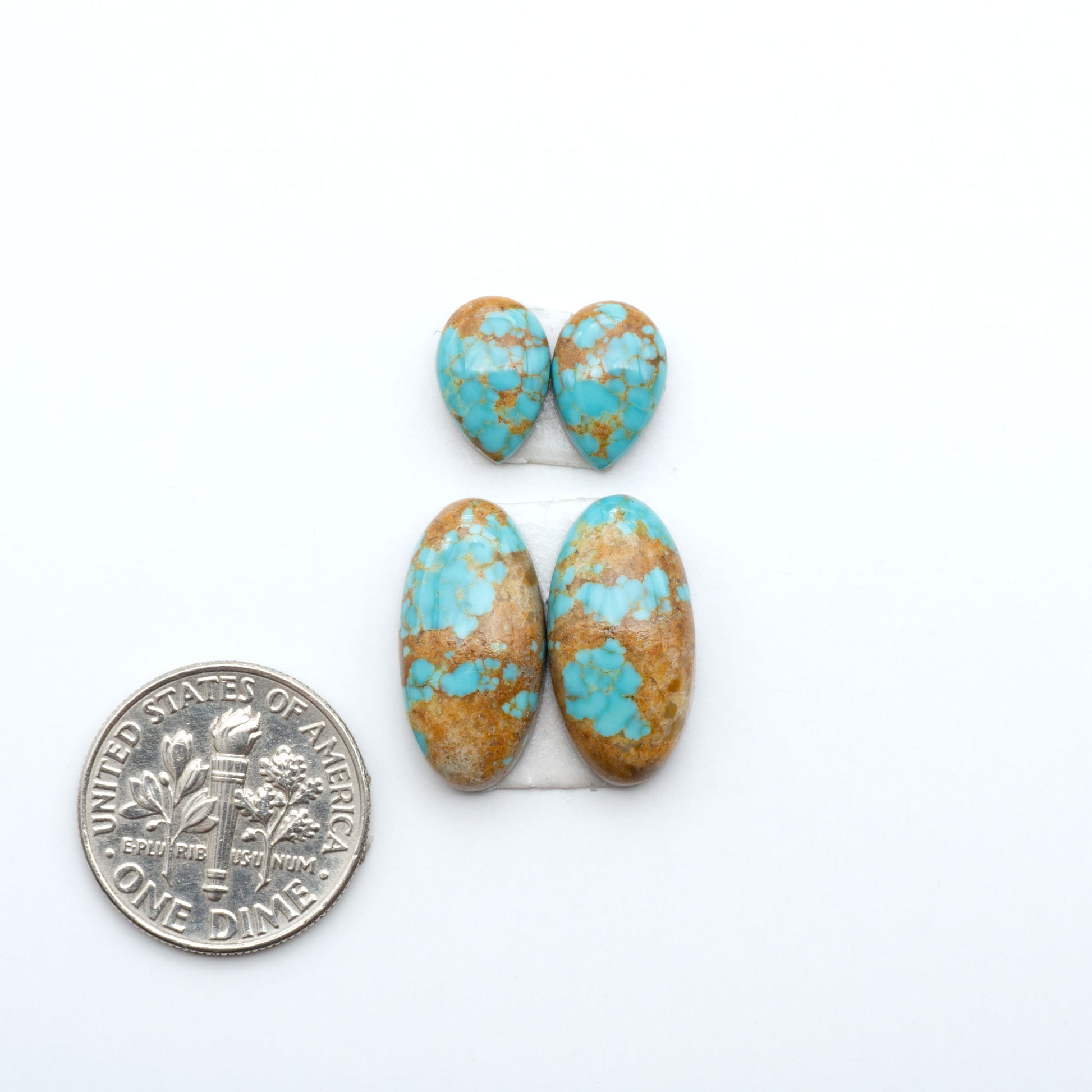 Number 8 Turquoise cabochons, blue and green color with brown matrix, polished stones on a white background, with a US dime for scale